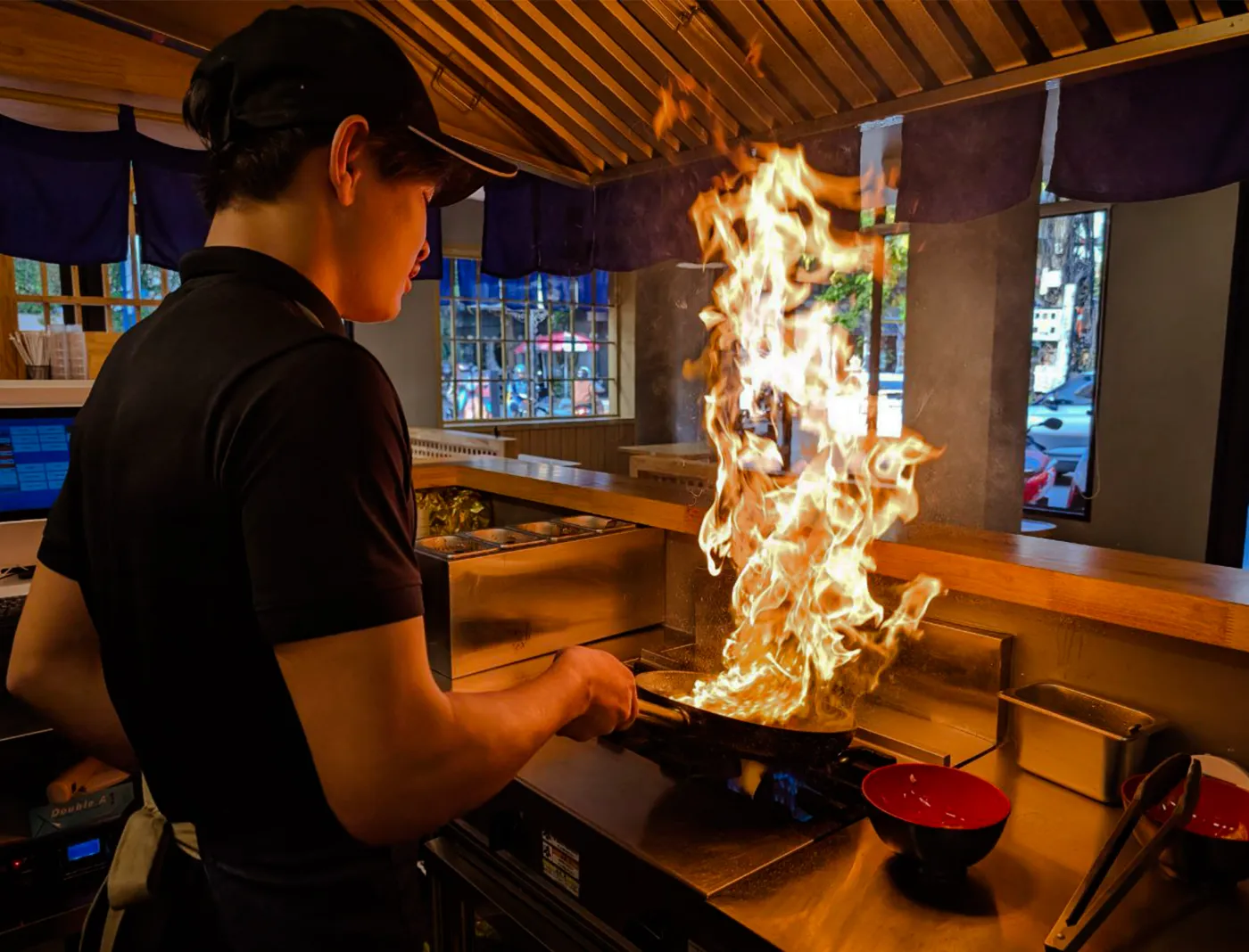 Chef cooking over open flame at Nabe-En